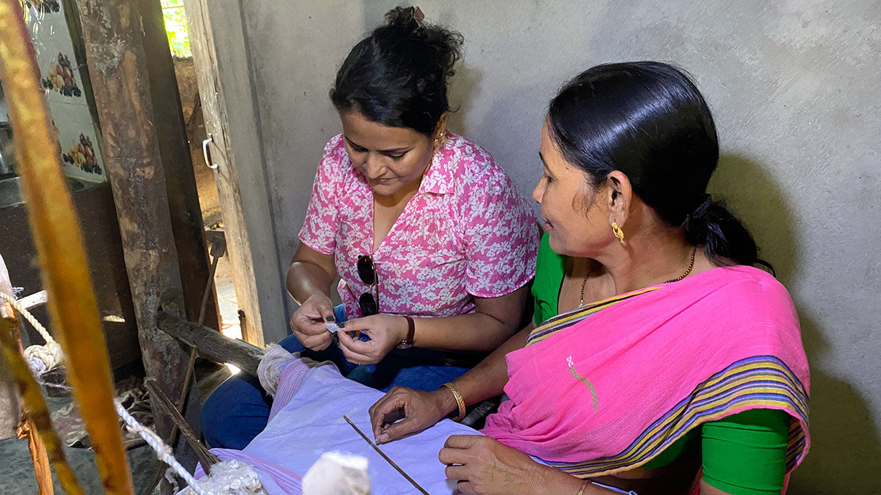 Two women working on handloom weaving